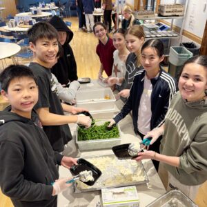 Several students around a table packaging food